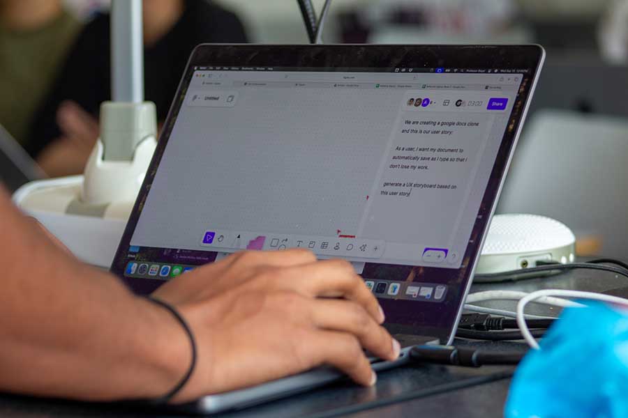 Close-up image of hands working on a laptop.